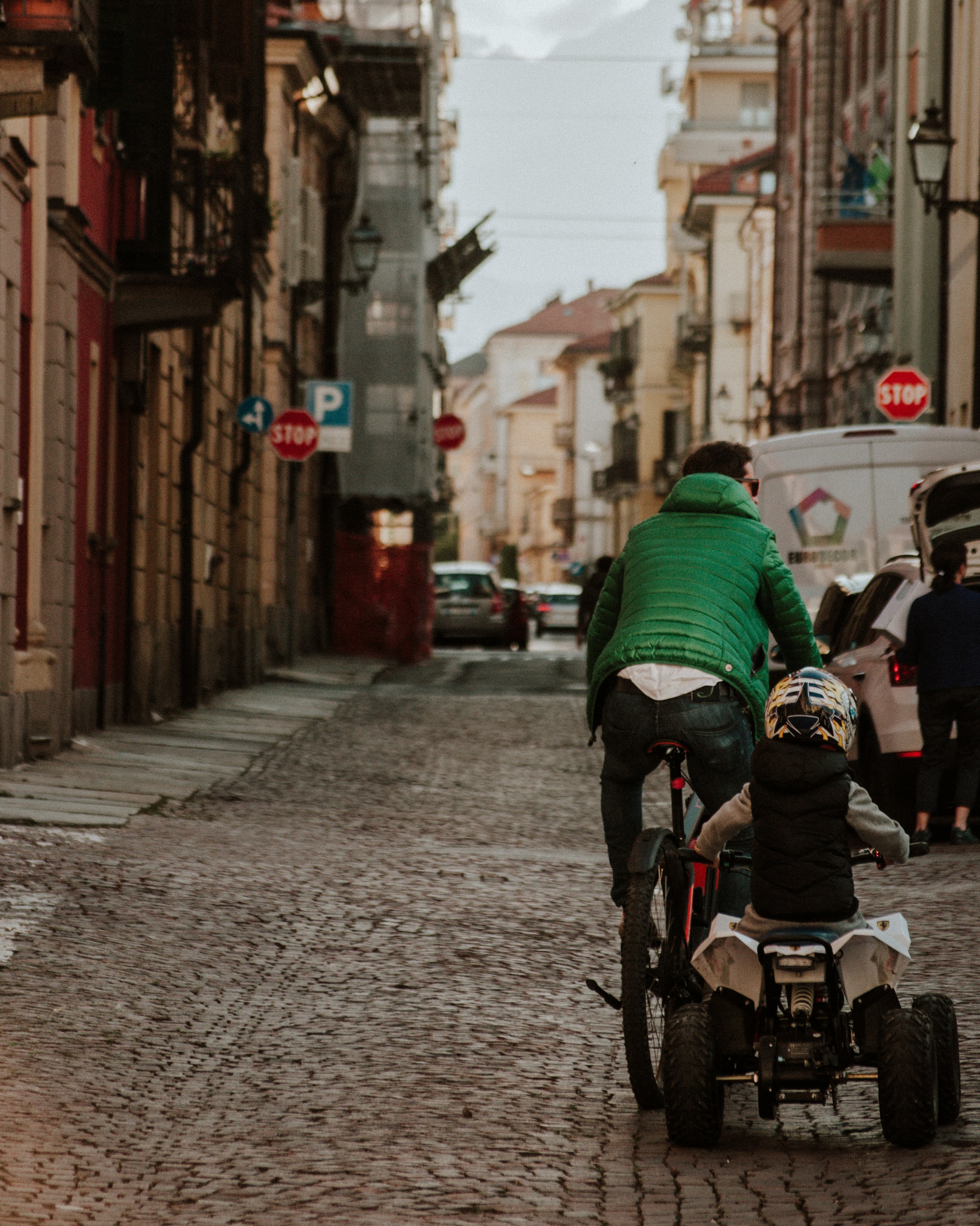 man in green and black jacket riding on black and gray motorcycle during daytime